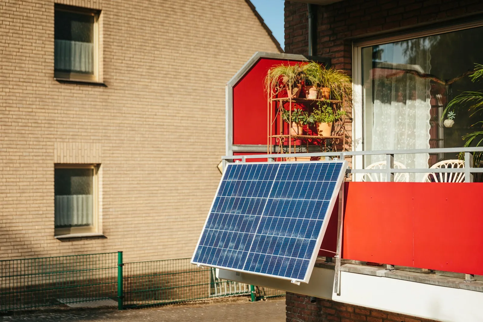 A plug-in solar panel angled out from a balcony railing